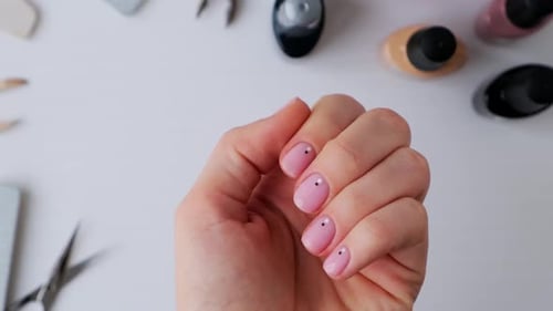 Woman's Hand Displaying a Light Pink Manicure