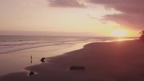 Person Walking along Coast at Sunset