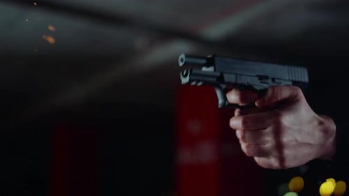 Adult Holding Gun at Night in Dark Environment