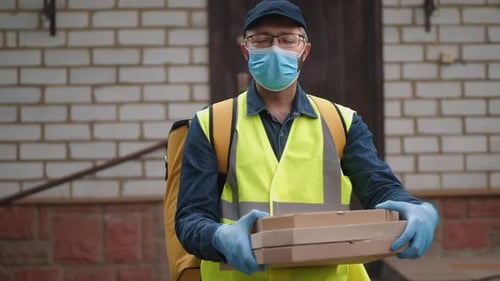 Portrait of a Courier in a Medical Mask and Gloves