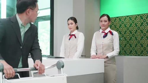 A businessman loading her luggage at the check-in counter at airport