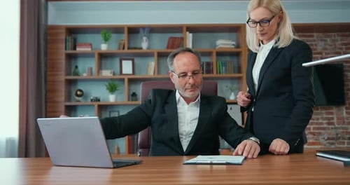 Man Working at Office with a Woman Presenting Documents