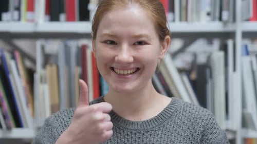 Woman Gives Thumbs Up in School Library