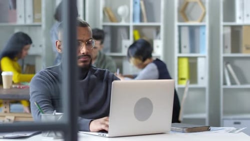 Gloomy Black Web Developer Working on Laptop