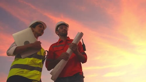 Construction Engineers Discuss Plans at Sunset