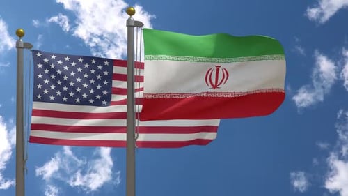 USA and Iran Flags Waving in Wind Against Blue Sky