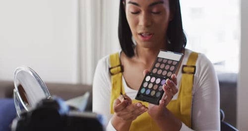 Vloguera mestiza de género fluido que graba un vlog de maquillaje en casa