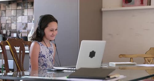 Girl with Headphones Using Laptop at Home