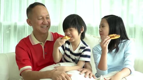 Father and Children Enjoying Pizza at Home