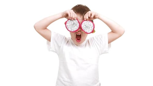 Playful Child Posing with Dragon Fruit Slices
