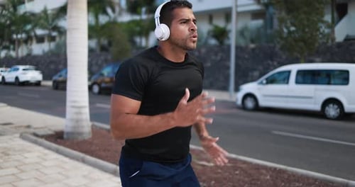 Young Man Jogging with Headphones in the City
