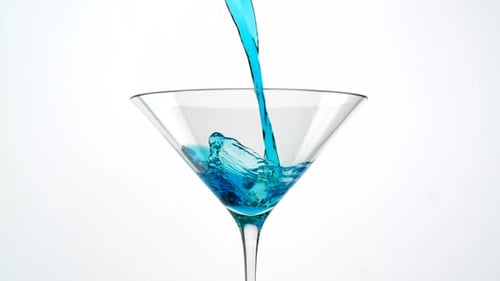Bright Blue Liquid Pours into a Martini Glass