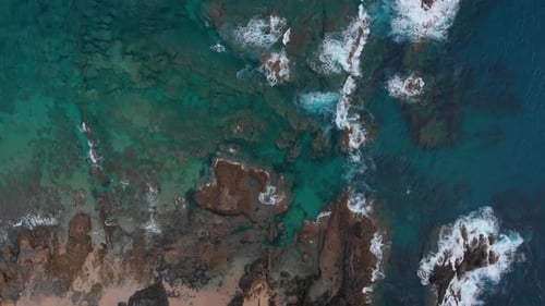 Aerial shot view of shallow rocks sea shoreline in slow motion