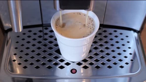 Espresso Machine Dispenses Coffee into a White Cup