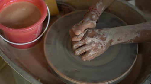 Slowmotion Closeup Shot of a Teacher Potter Teaching His Apprentice How To Make a Clay Bowl