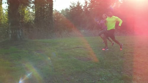 Man and Woman Jogging on Grassy Hill