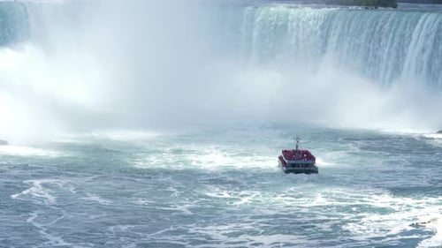 Tourist cruise boat approaching the Niagara Falls waterfalls, steady
