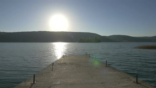 Reflexão do sol na água vista de uma doca