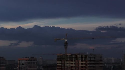 Time Lapse of Construction at Sunset with City in the Background