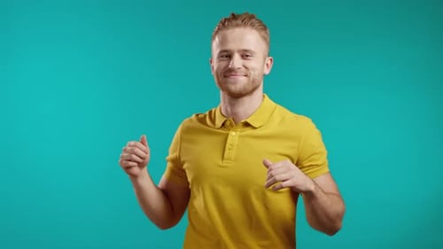 Blonde Man Dancing Positive on Blue Studio Background