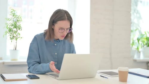 Frustrated Woman Using Laptop at Bright Desk