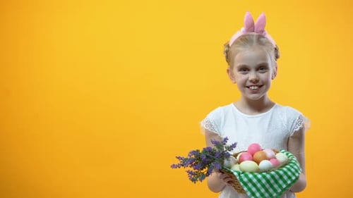 Smiling Little Kid Showing Basket With Colorful Eggs Yellow Background, Easter