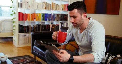 Man Uses Tablet Device at Home Indoors