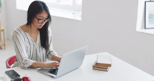 A Woman Freelancer Works at Home Using a Laptop