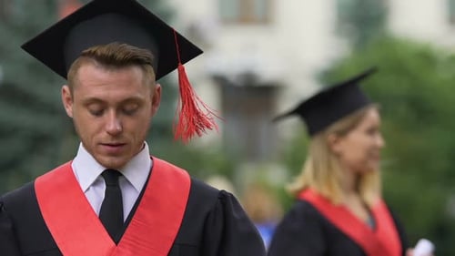 Smiling Male Student Reading Speech Before Graduation Ceremony at University