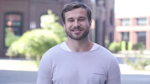 Smiling Man Standing Outside in an Urban Area