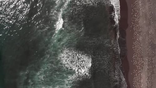The Drone Flies Over the Coast. Dark Waves Roll Ashore