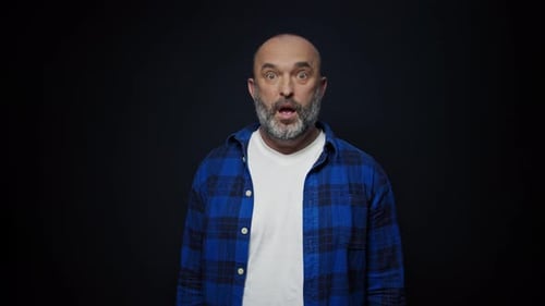 Man Expressing Shock in Front of Black Background