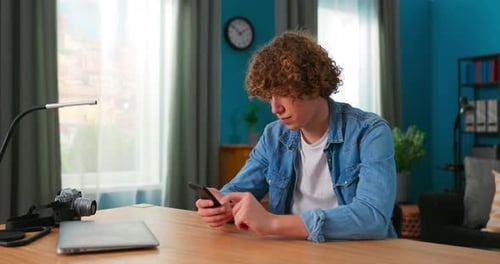 Teen Using Phone at Desk Indoors