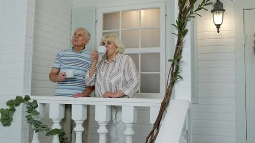 Elderly Couple Relaxing with Tea on Porch