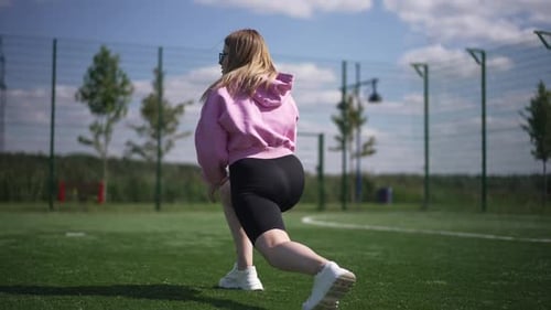 Woman Stretching Outdoors on Sports Field