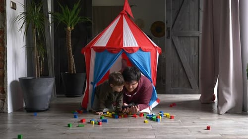 Young Adult and Child Play in Colorful Tent