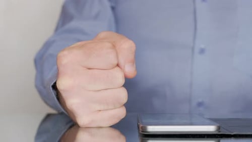 Boss Clenching His Fist Signaling Anger and Frustration As His Hand Rests on an Office Table