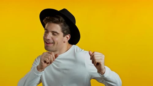 Enthusiastic Man Dancing Happily on Yellow Background