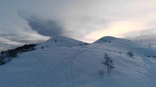 Aerial View of Snow Capped Mountain Range Landscape in Winter During Sunset