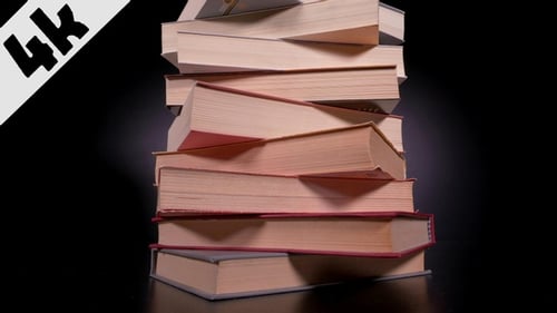 Stack of Books Accumulates on Black Background