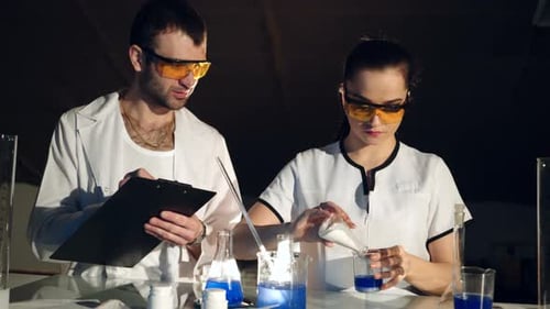Scientists Conducting Chemical Experiment in Laboratory Setting