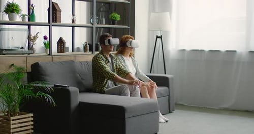Couple Experiences Virtual Reality Together in Living Room