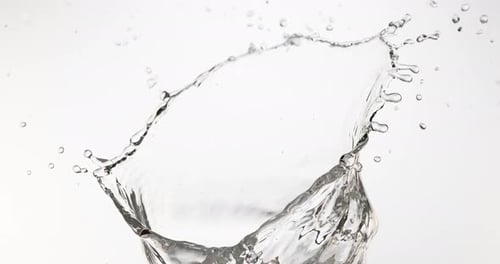 Agua chorreando contra fondo blanco, cámara lenta 4K