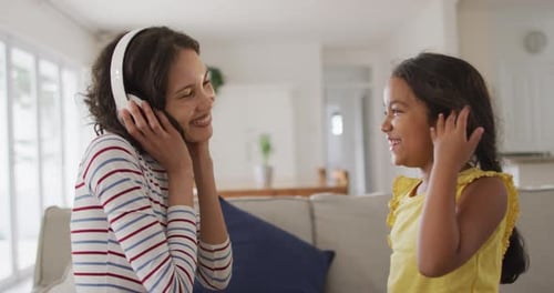 Smiling Woman and Girl Enjoying Music at Home