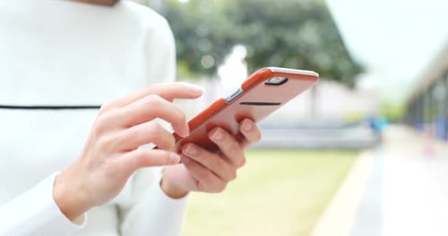 Person Swiping on a Smart Phone Outdoors