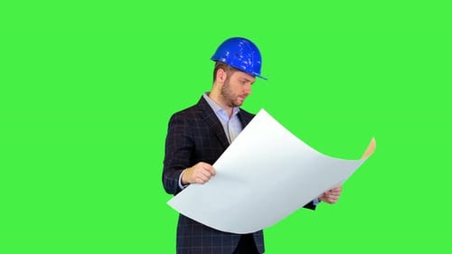 Erfolgreicher junger Architekt im Bauhelm und Anzug analysiert Blaupause Überwachung des Gebäudes