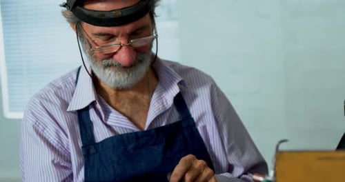 Goldsmith using digital tablet in workshop 4k