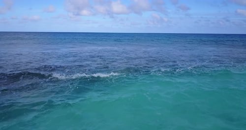 Daytime overhead travel shot of a white sand paradise beach and blue ocean background in colourful