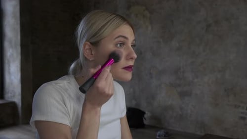 Woman Applies Makeup with Brush Close Up