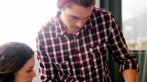 Young Adults Working Together at Desk in Workplace